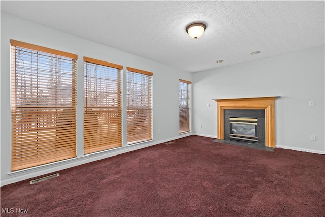 unfurnished living room with carpet and a textured ceiling