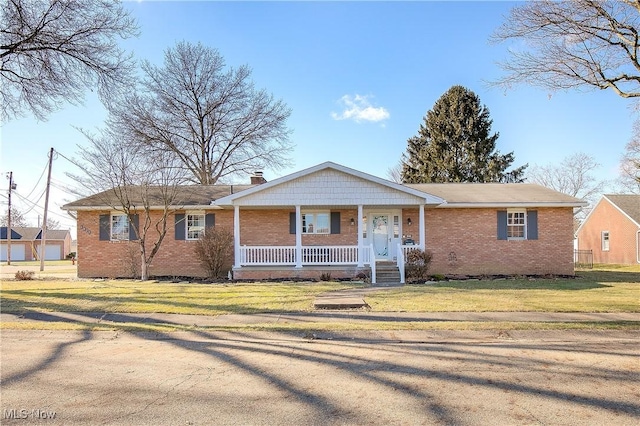 ranch-style house featuring covered porch and a front lawn