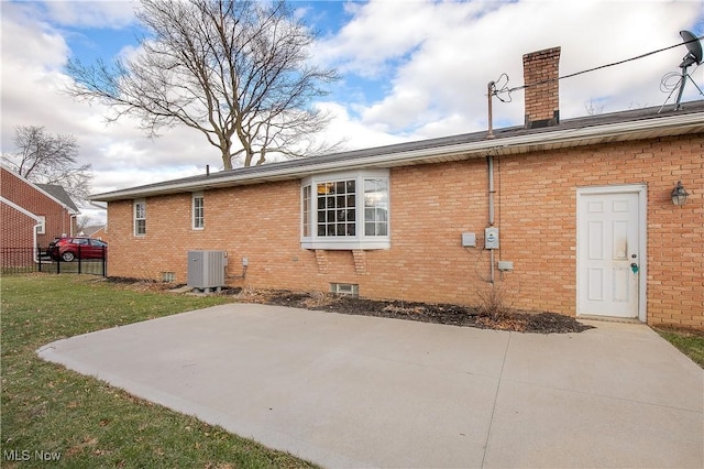 rear view of property featuring a lawn, a patio, and central air condition unit