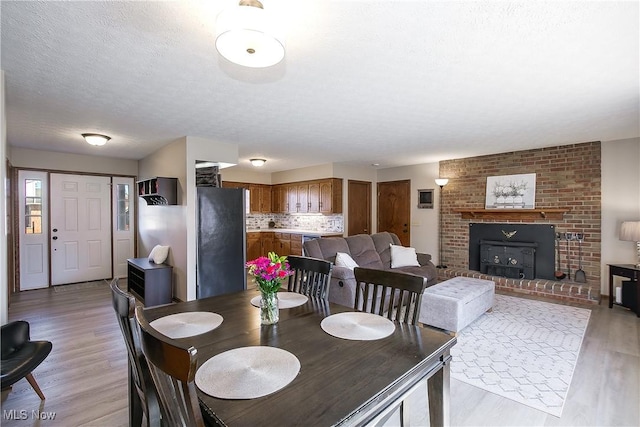 dining area featuring a textured ceiling and light hardwood / wood-style floors