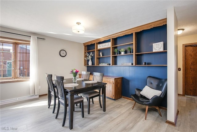 dining area featuring a textured ceiling and light wood-type flooring