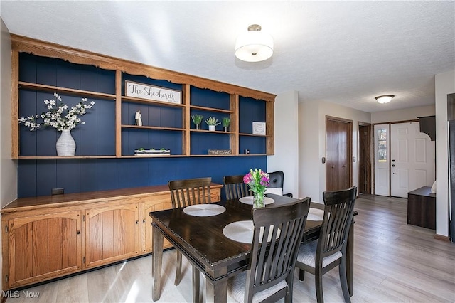 dining area featuring a textured ceiling and light hardwood / wood-style floors