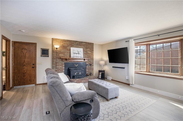 living room with a wood stove and light wood-type flooring