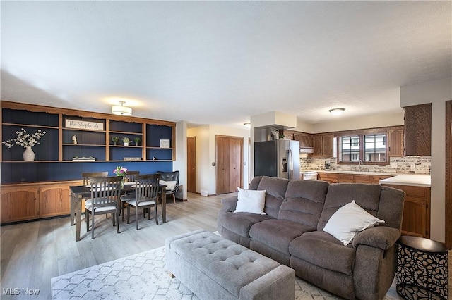 living room with sink and light hardwood / wood-style flooring