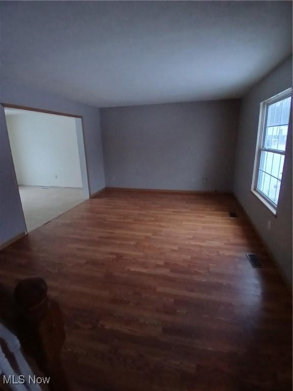 unfurnished room with dark hardwood / wood-style flooring