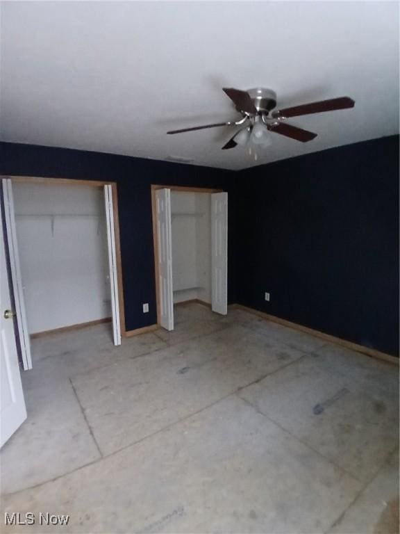 unfurnished bedroom featuring multiple closets and ceiling fan