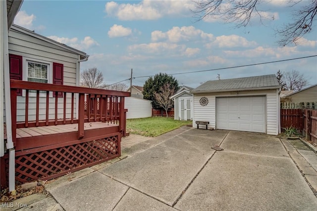 view of yard with a garage, an outbuilding, and a deck