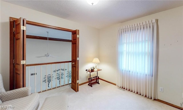 sitting room with carpet flooring and a textured ceiling