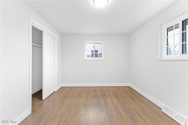 unfurnished bedroom featuring a closet and light wood-type flooring