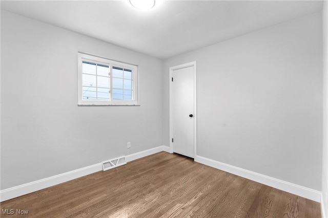 unfurnished room with hardwood / wood-style flooring