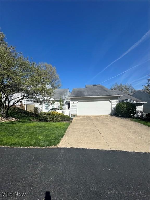 view of front of home featuring driveway, a front lawn, and a garage
