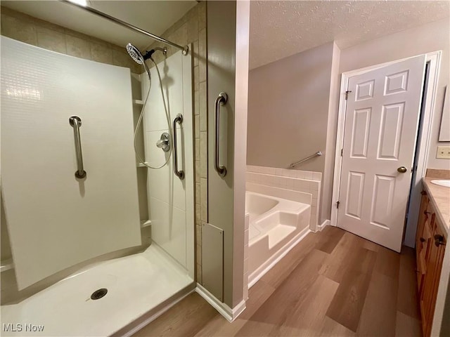 721 Winding Way, Akron, OH 44313 - bathroom with wood finished floors, a bath, vanity, a stall shower, and a textured ceiling