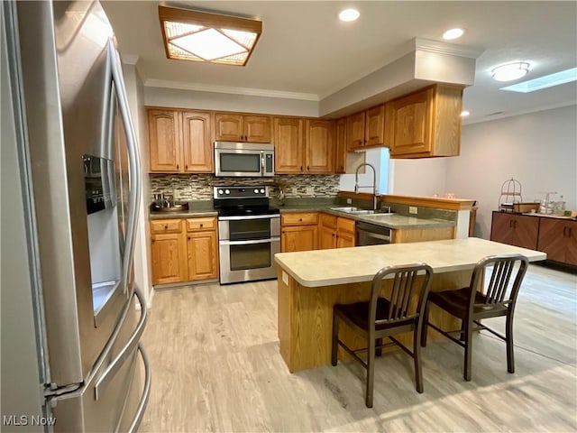 721 Winding Way, Akron, OH 44313 - kitchen with stainless steel appliances, a sink, ornamental molding, a kitchen bar, and a peninsula