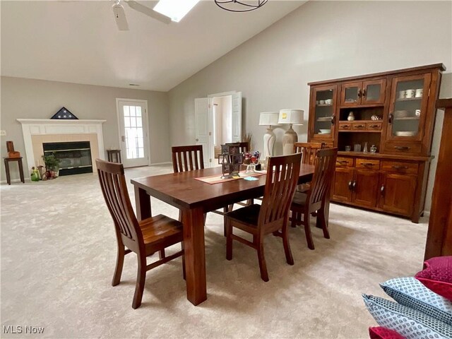 721 Winding Way, Akron, OH 44313 - dining space featuring light colored carpet, a ceiling fan, a glass covered fireplace, and high vaulted ceiling