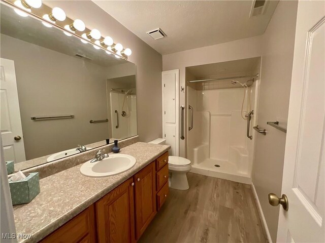 721 Winding Way, Akron, OH 44313 - bathroom featuring wood finished floors, a shower, vanity, toilet, and baseboards