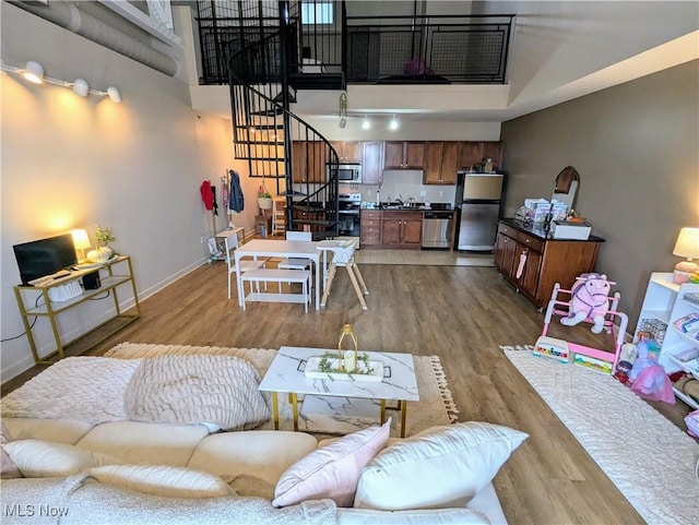 living room featuring wood-type flooring and a high ceiling