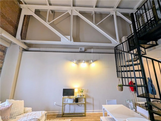 interior space with hardwood / wood-style floors and a towering ceiling