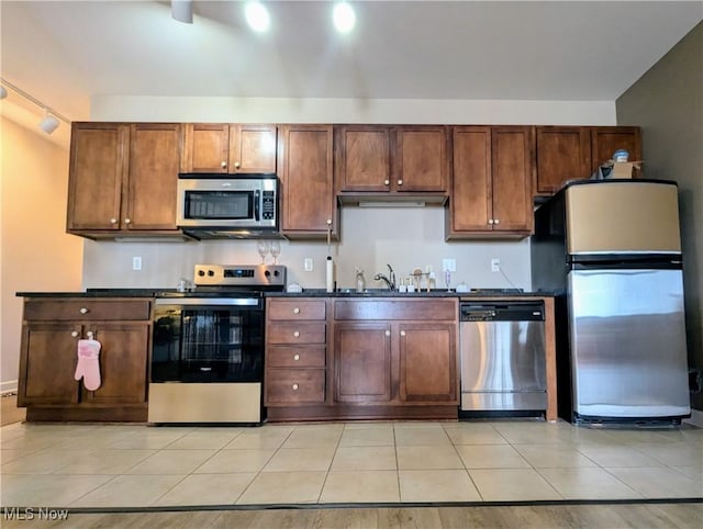 kitchen with light tile patterned floors, stainless steel appliances, and sink