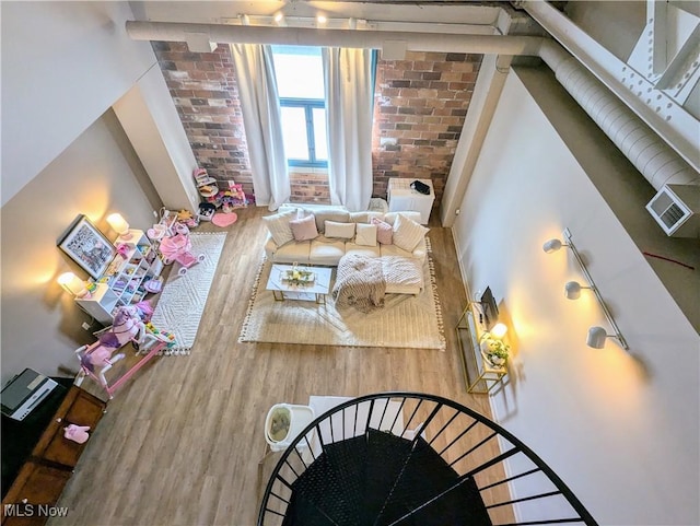 living room featuring brick wall and hardwood / wood-style floors