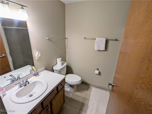 bathroom featuring tile patterned flooring, vanity, and toilet