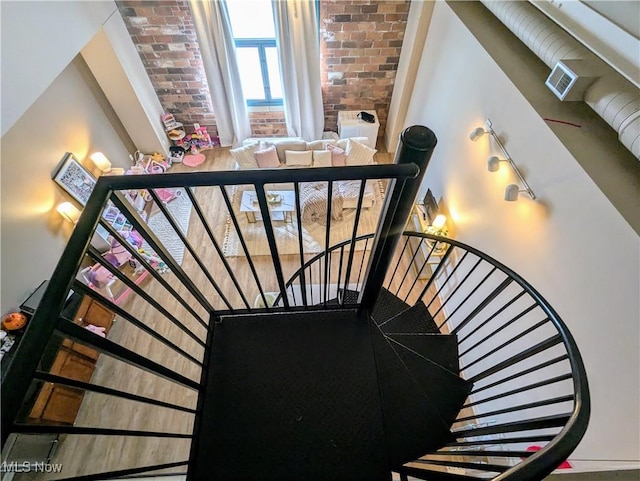 stairway featuring brick wall