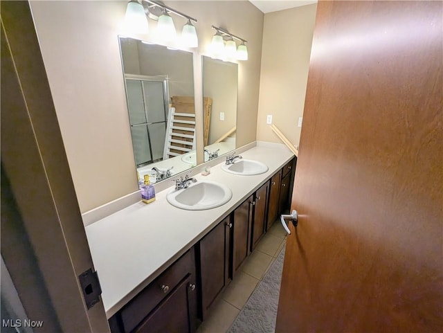 bathroom featuring walk in shower, vanity, and tile patterned flooring