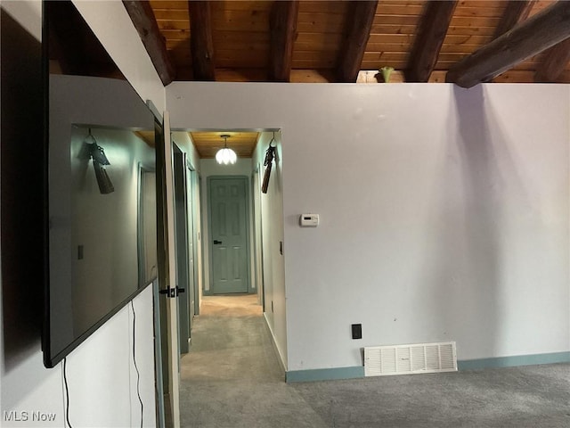 hall featuring beam ceiling, carpet floors, and wooden ceiling