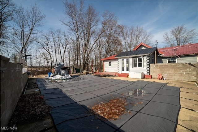 view of swimming pool with entry steps, a patio area, a fenced backyard, and an outbuilding