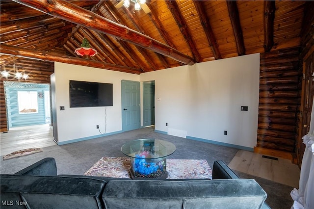 living area featuring rustic walls, baseboards, and beamed ceiling