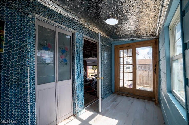 doorway with an ornate ceiling and wood finished floors