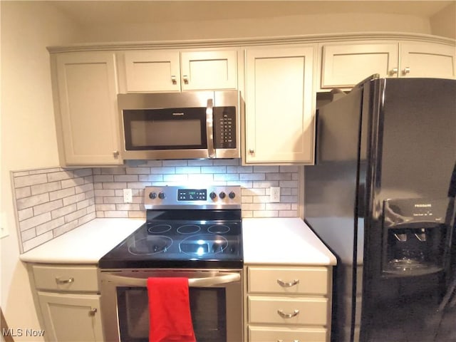 kitchen featuring stainless steel appliances, white cabinetry, and decorative backsplash