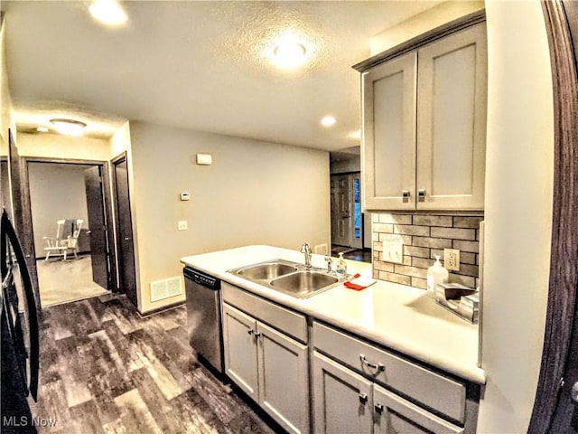 kitchen with sink, gray cabinetry, dark hardwood / wood-style flooring, decorative backsplash, and stainless steel dishwasher