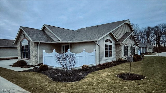 view of side of home with central AC unit and a yard