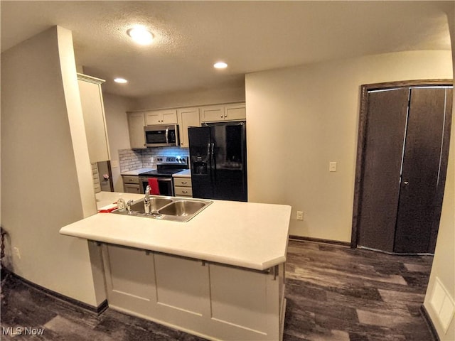 kitchen with sink, white cabinetry, appliances with stainless steel finishes, a kitchen breakfast bar, and kitchen peninsula