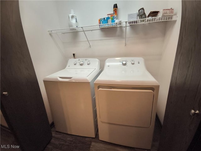 laundry room with dark hardwood / wood-style flooring and washing machine and dryer