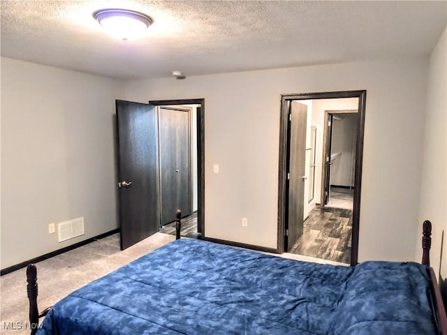 carpeted bedroom featuring a textured ceiling