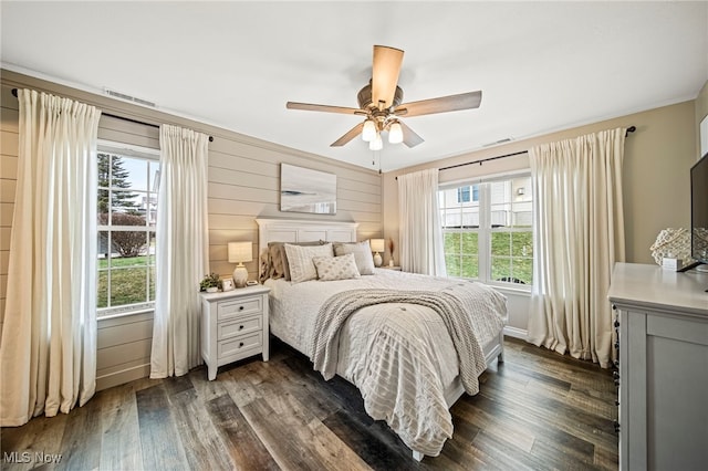 bedroom featuring dark hardwood / wood-style floors, ceiling fan, and wood walls