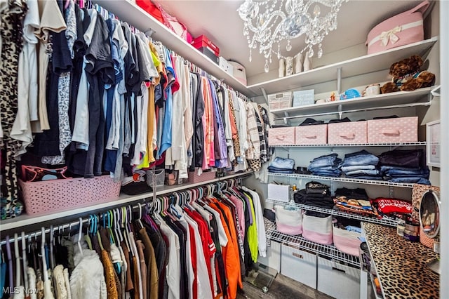 walk in closet with an inviting chandelier