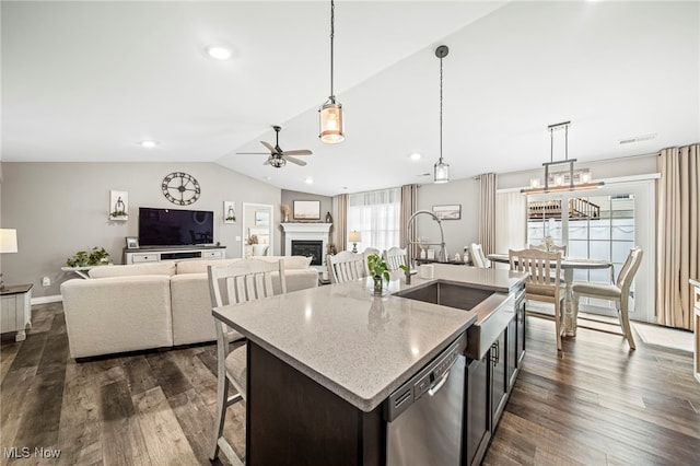 kitchen featuring pendant lighting, sink, an island with sink, vaulted ceiling, and stainless steel dishwasher