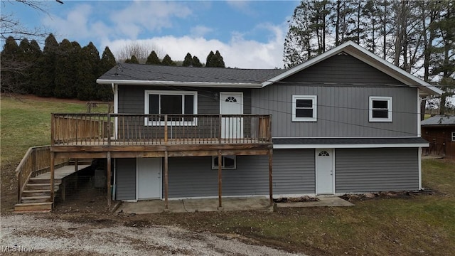 back of house with a wooden deck and a yard