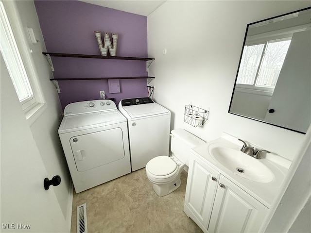 bathroom featuring vanity, washer and clothes dryer, and toilet