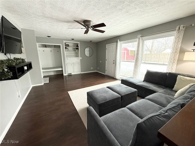 living room with ceiling fan, dark hardwood / wood-style flooring, and a textured ceiling