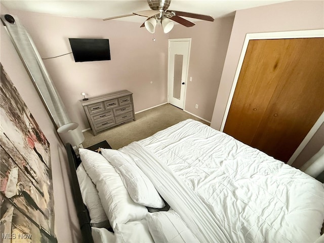 bedroom featuring ceiling fan, dark carpet, and a closet