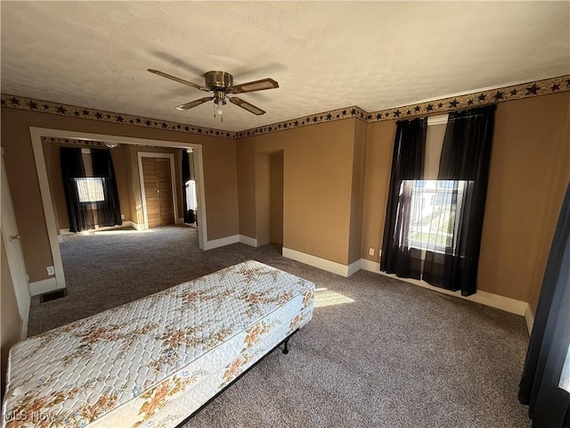 unfurnished bedroom featuring a textured ceiling, ceiling fan, and carpet flooring