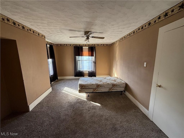 unfurnished bedroom with ceiling fan, a textured ceiling, and carpet