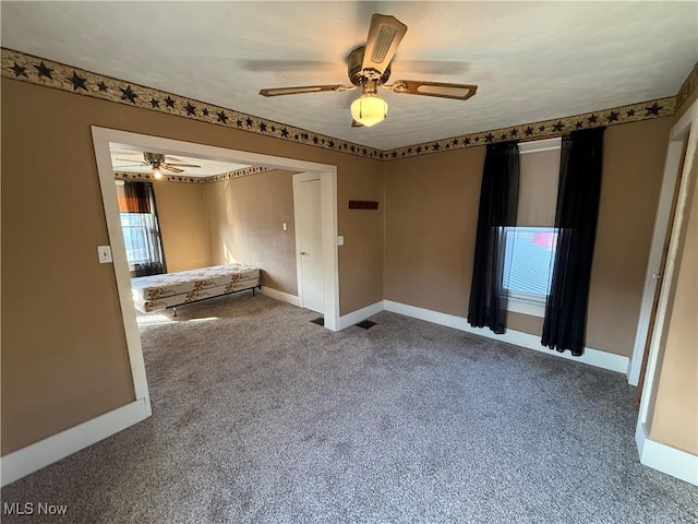 unfurnished room with carpet flooring and ceiling fan