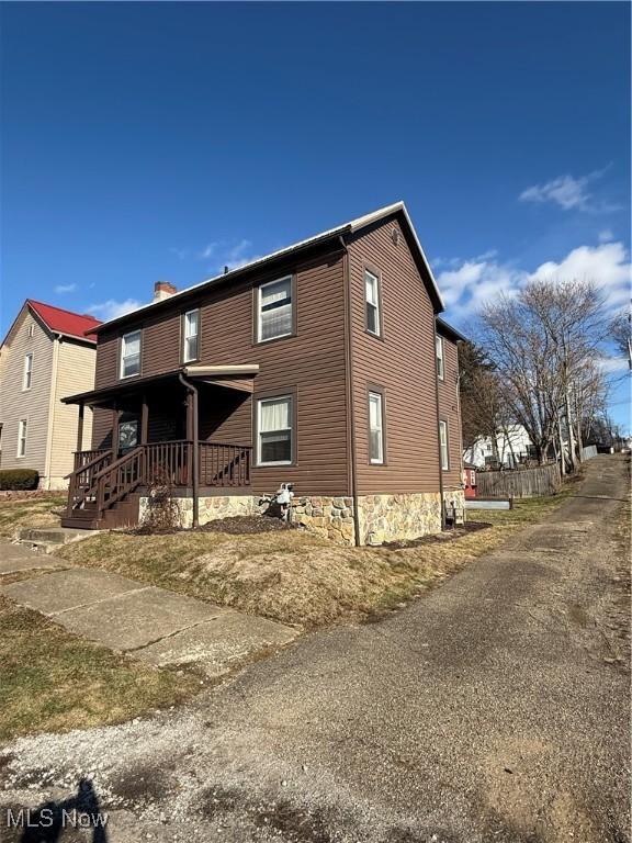 rear view of house featuring a porch