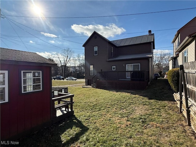 rear view of property with a wooden deck and a yard