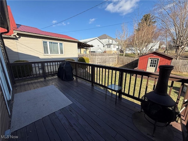 deck featuring a storage shed, grilling area, and a lawn