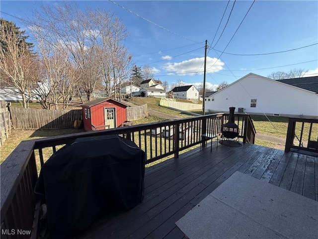 wooden terrace with area for grilling, a yard, and a shed